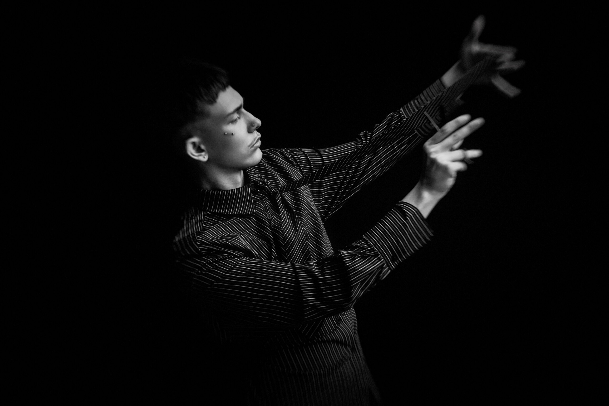 Igor Jagodziak z nożyczkami w teatralnym ujęciu z efektem ruchu
